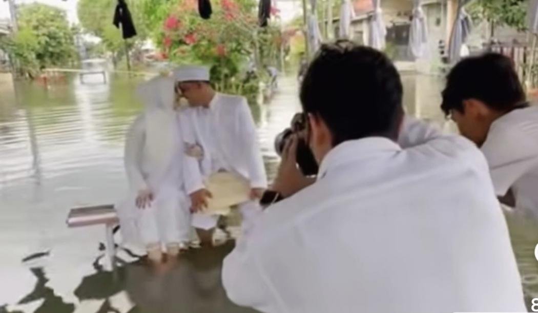 Viral Sepasang Pengantin Foto Pernikahan di Tengah Banjir, Netizen: Ala-Ala Pantai Banget!